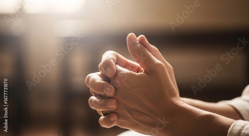 Hands clasped in prayer, seeking solace and hope in gentle light