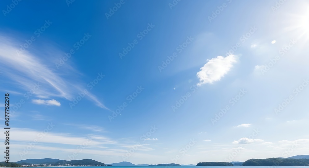 Fototapeta premium Vast Blue Sky with Wispy Clouds Over Calm Water.