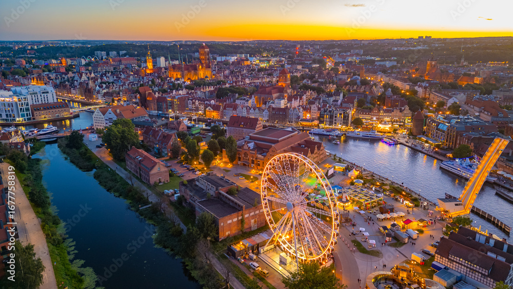 Fototapeta premium Sunset panorama of Gdansk behind a ferris wheel, Poland