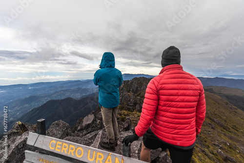 Young hiking couple at the summit of Cerro Urán on a cold morning in Chirripo National Park, Costa Rica.