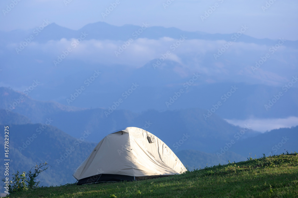 Obraz premium Adventurer tents during overnight camping site at the beautiful scenic sunset view point over layer of mountain for outdoor adventure vacation travel