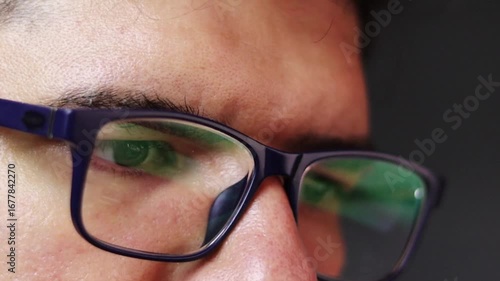 Wallpaper Mural Close-up of the eyes of an adult man with dark circles, wearing glasses, avidly reading a computer screen, with facial expressions representing focus and attention. Office work, routine, fatigue Torontodigital.ca