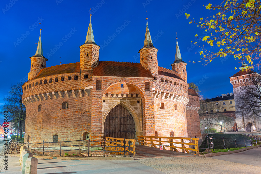 Fototapeta premium Night view of the Barbikan gate situated in the Polish city Krak