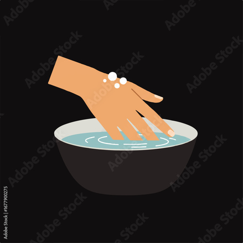 Hand soaking in a bowl of water with soap bubbles on the wrist