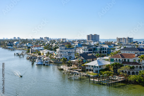 Boat idling by waterfront homes in Fort Myers Beach on Estero Island, southwest Florida in Lee County