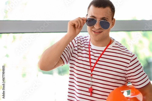 Happy male lifeguard with w...