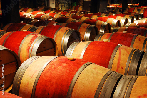 Wine ages in wooden barrels in a cellar in the Napa Valley