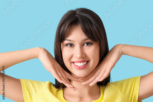 Smiling young woman on blue...