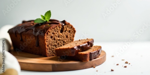 Delicious chocolate glazed loaf cake, freshly baked and ready to be enjoyed, sits on a wooden board with slices, perfect for a sweet treat