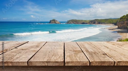 Wooden table overlooking a dynamic ocean beach with rolling waves and blue sky