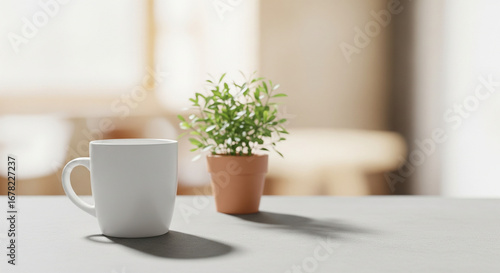 White mug and small potted plant sitting on a table in a bright room setting