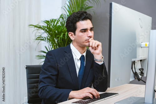 Young Businessman or Programmer looking worried and stressed over working on a computer code at office.