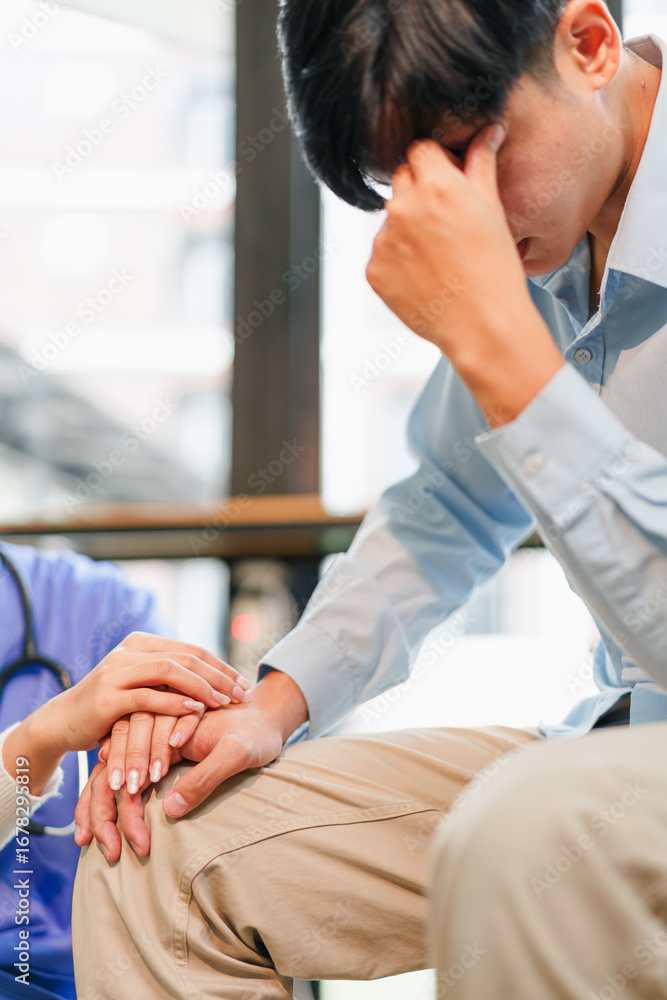 Obraz premium Young man stressed and emotional patient receiving comforting touch from medical caregiver in clinic waiting room, anxiety and support visible