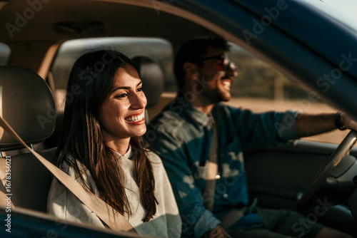 Happy couple enjoying road trip in comfortable car