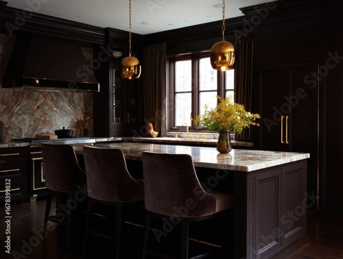 A dramatic kitchen island, accented with rich dark cabinetry and polished gold accents, sits in a sophisticated, dark space.