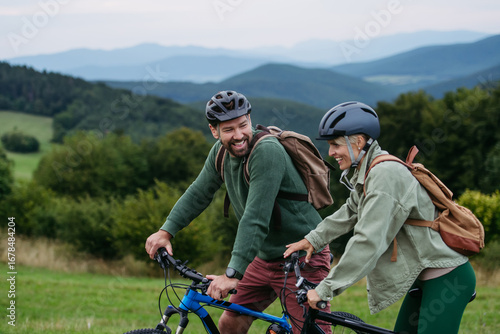 Fototapet Couple cycling together in nature, smiling and enjoying outdoor adventure