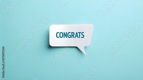 A white congrats speech bubble on a light blue background in a flat lay
