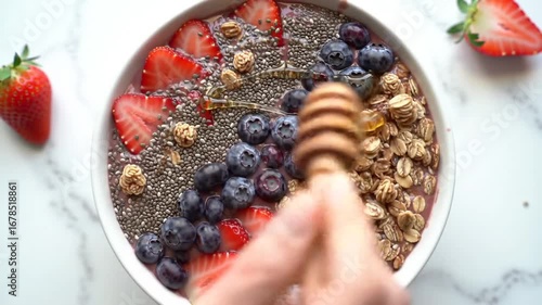 Healthy Smoothie Bowl with Fresh Berries, Granola, and Honey Being Drizzled on Top