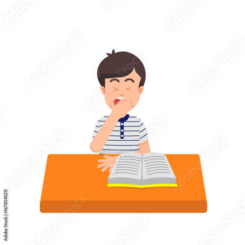 Little boy yawns while reading a book at his desk