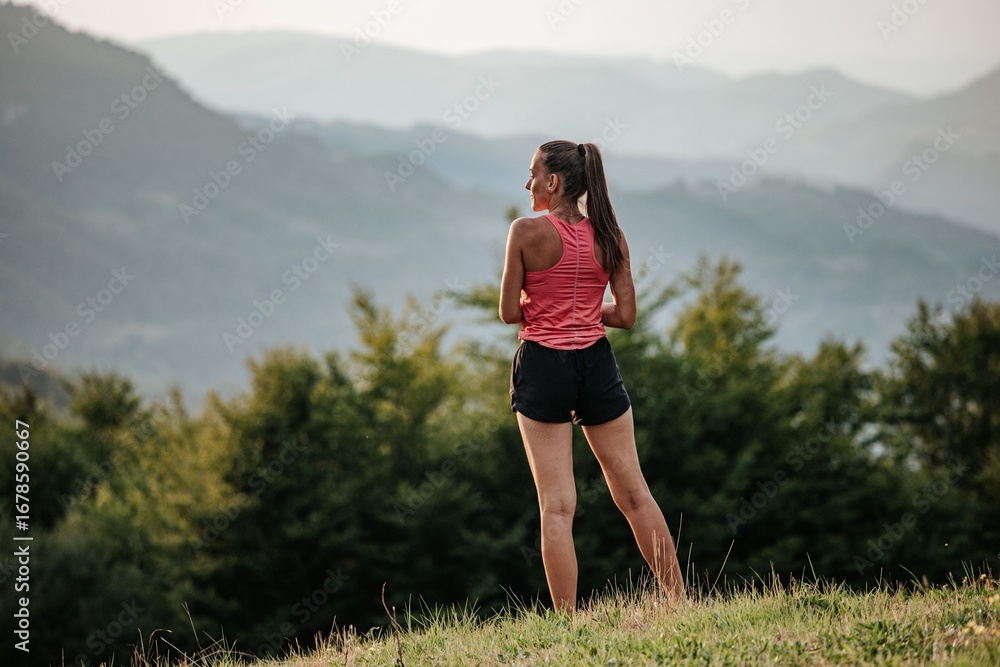 Obraz premium Woman enjoying mountain view in athletic wear.