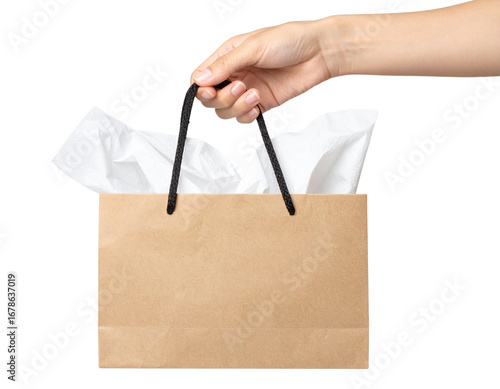 Hand holding a blank brown kraft paper shopping bag with tissue paper against a clean white background