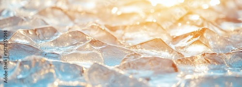 Cracked ice surface with sharp translucent shards reflecting sunlight near a water body at dawn
