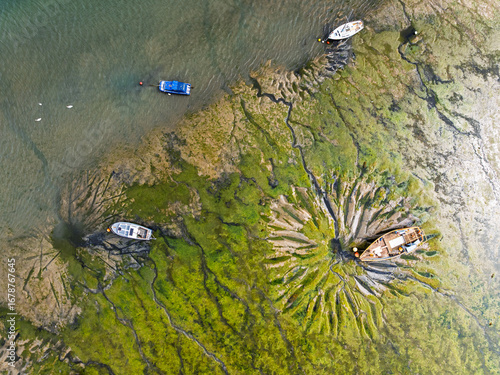 Top Down over boat and mud from drone, Paulsgrove Lake, Portchester Castle, Portchester, Fareham, Hampshire, England