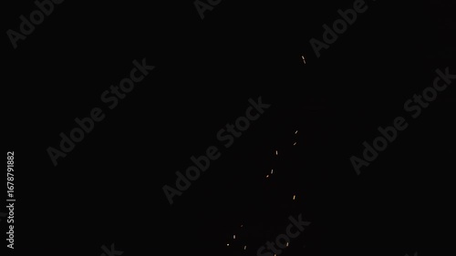 Slow motion of sparks and embers from campfire flying over black background