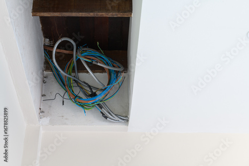 фотографія Messy bundle of electrical wiring detail inside ceiling during house renovation