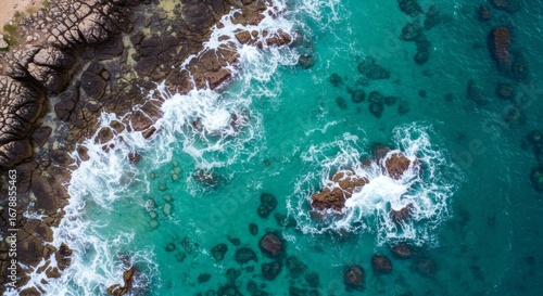 Turquoise Tide Embrace Rocks Meet Azure Sea on Sandy Shore.