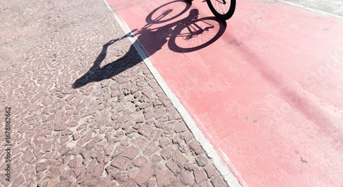 Shadow of a bicycle projected onto a cycle path. Person exercising. Cyclist in action. Lifestyle,