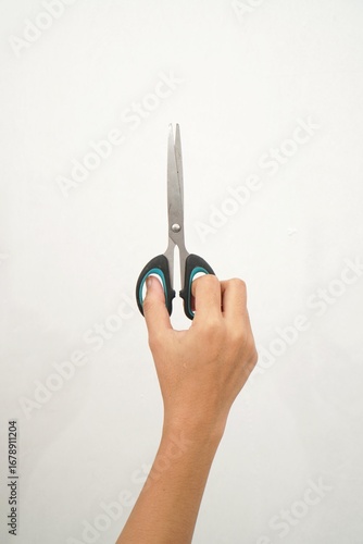 Female hands holding black scissors Isolated on white background. Closeup.
