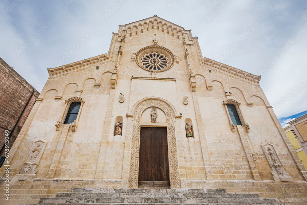 Fototapeta premium Daytime panoramic view of the historic town of Matera in southern Italy. The image highlights ancient stone houses, narrow streets, and the iconic Matera Cathedral rising above the Sassi cave dwelling