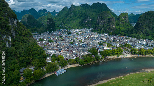 Aerial view of the town nestled amid the towering karst mountains, kissed by the Li River's emerald waters, Yangshuo, China.