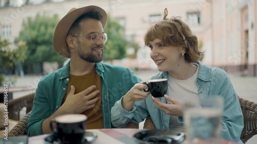 Young couple enjoying a relaxing moment together at an outdoor cafe.