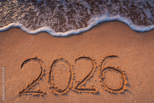 Fototapeta Naklejka Na Ścianę i Meble -  Happy New Year nature background concept, ocean sunrise and 2026 text on the beach sand and sea wave