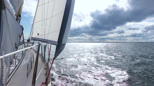 Luxury sailing yacht under genoa and mainsail cruising in light wind during regatta on the Baltic Sea. Elegant yachting lifestyle, sport, and summer vacation at sea