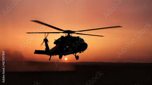 Silhouette of helicopter at sunset over desert landscape creating dust clouds. Helicopter against a golden sunset evokes feelings of adventure, power, and military strength.