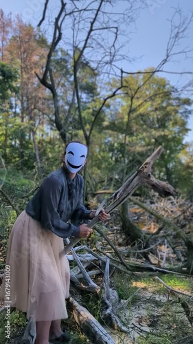 Animegao mask hanging on tree near water, mysterious atmosphere.