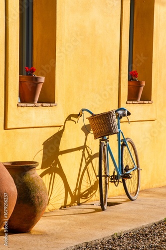 Vintage Blue Bicycle Against Yellow Wall