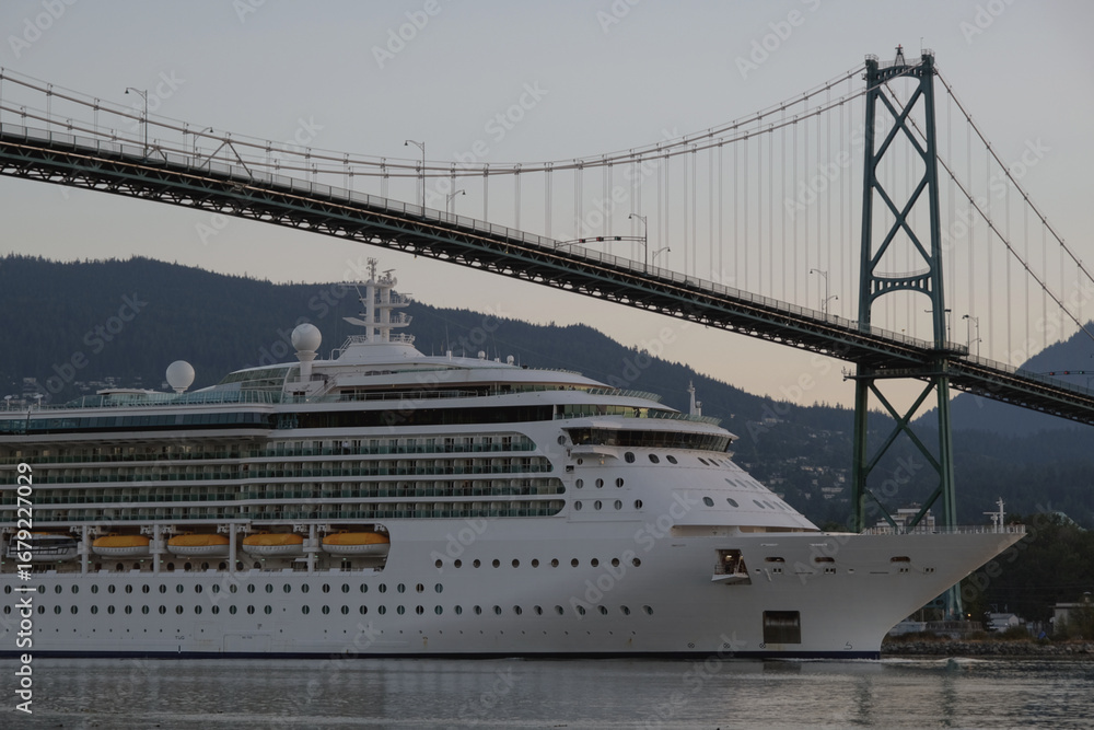 Fototapeta premium Modern cruiseship or cruise ship liner Serenade, Radiance, Brilliance or Jewel arrival into Vancouver port, Canada during sunrise after cruise to Alaska with Stanley Park landscape