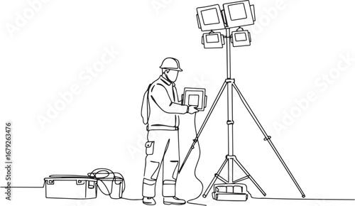 Construction worker setting up lighting equipment on a construct