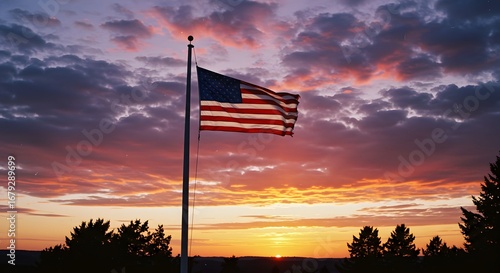 An American flag flies at half-mast against a vibrant sunset, evoking a sense of patriotism and reflection