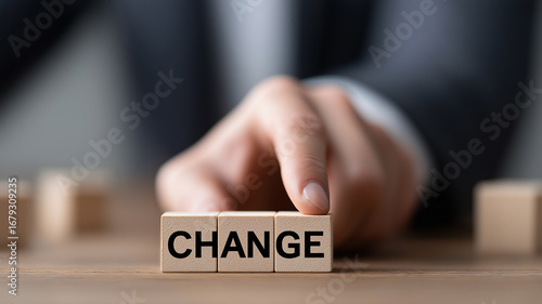 Close-up of businessman hand in formal suit pointing at wooden block with engraved word CHANGE symbolizing transformation, growth, and strategic decision-making in business