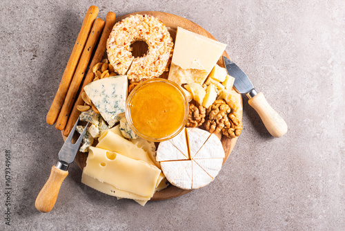 Wooden charcuterie board with various cheese and olives. Brie. Camembert. Parmesan, feta, blue cheese. Italian, French cheese