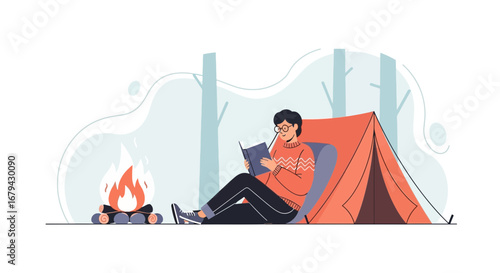 Man reading a book by the campfire in nature exploring the outdoors and camping