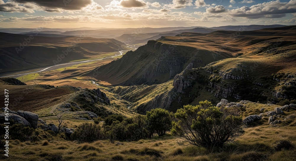 Fototapeta premium Dramatic Golden Hour Landscape with Winding River Through Rolling Hills and Valleys