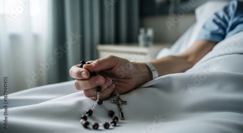 A person lying in bed holding a rosary beads in hospital