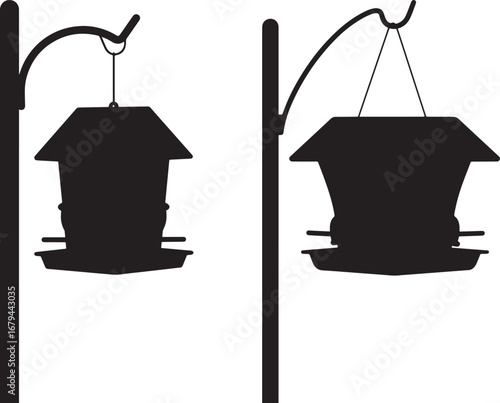 Two black silhouette bird feeders hanging from poles isolated on white background silhouette