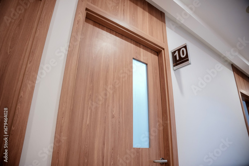 Doctor's examination room with a wooden door marked with the number 10 on the wall.